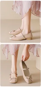 Macro detail of beige patent leather Mary Jane shoes with bow and square toe