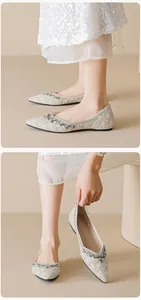 Détails de chaussures plates à bout pointu ornées de perles blanches et de cristaux brillants