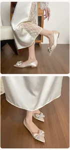 Detalle de bailarinas puntiagudas color champán con lazo brillante y pedrería elegante