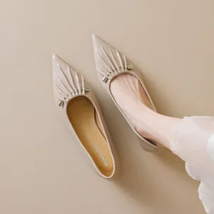 Elegante beige spitse platte schoenen met lederen plooien en zilveren gespen