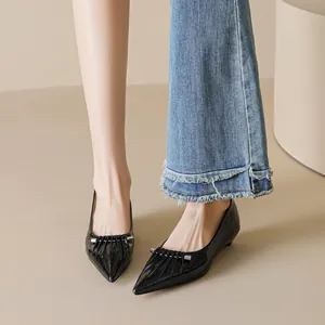 Elegante zwarte spitse schoenen met lage hak en geplooide metalen details in lakleer