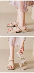 Close-up of elegant apricot square-toe slide sandals with delicate bow and block heel