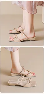 Detailed close-up of beige bow-knot slippers featuring square toe and chunky low heels