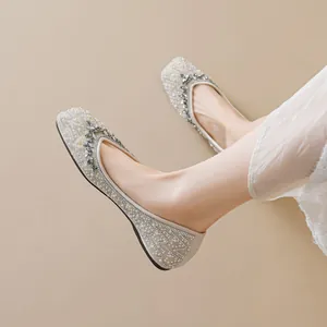 Chaussures plates beiges à bout carré avec perles et strass portées par un mannequin