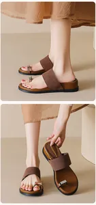 Detail view of brown matte toe-ring sandals featuring elegant silver metal ornaments