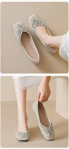 Detailed view of square-toe flats with shimmering crystals and flower rhinestone buckle
