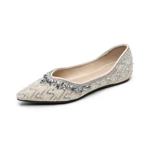 Elegante spitze Ballerinas mit Perlen und Steinen auf cremefarbenem Stoff