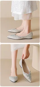 Detailed view of pointed toe flat shoes with sparkling crystals and pearl embellishments