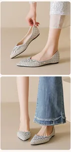 Detailed view of pointed flat shoes with elegant rhinestones and pearl embellishments