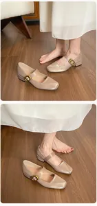 Detail von champagnerfarbenen Mary Janes mit eckiger Zehenpartie und Gold-Schnalle