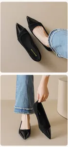 Close-up of black pointed-toe flat shoes featuring mixed matte suede and patent leather