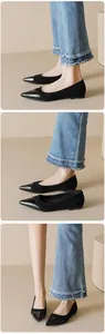 Detail view of black pointed toe flats featuring contrasting matte and glossy patent leather