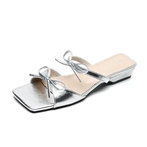 Elegant silver square toe slide sandals with delicate bow straps and a low wedge heel