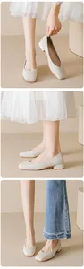 Detail of creamy white low block heel shoes with elegant square-round toe and soft leather