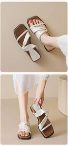Detail shot of white knotted leather strap and square toe flat sandals on model