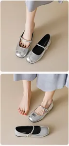 Macro detail of silver Mary Jane flat shoes featuring a slim ankle strap and metallic finish