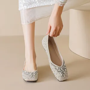 Elegant beige square toe flat shoes featuring decorative pearls and sparkling rhinestones