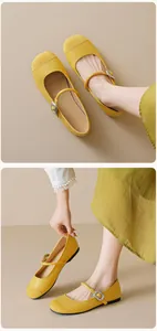 Detail of yellow Mary Jane flats featuring a mix of textures and silver square buckle