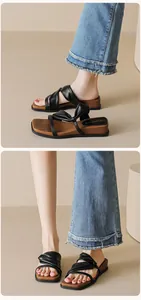 Detail of black leather platform sandal with pleated straps and faux wood wedge sole