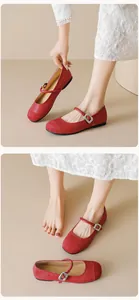 Detail of red Mary Jane flats with leather splicing and silver buckle closure