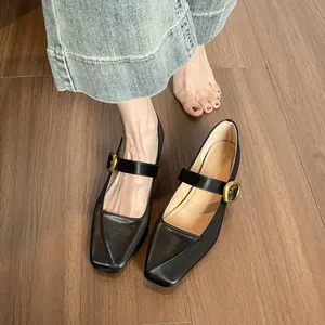 Schwarze Mary Jane Schuhe mit eckiger Zehenpartie und goldener Schnalle auf Holzboden