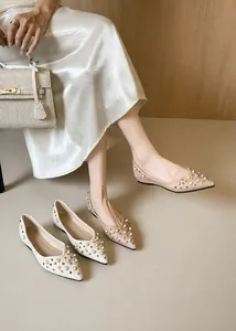 Détail de perles élégantes et clous métalliques sur chaussures plates en cuir pour femme