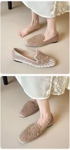 Close-up of champagne velvet ballet flats featuring intricate rhinestone and bead details