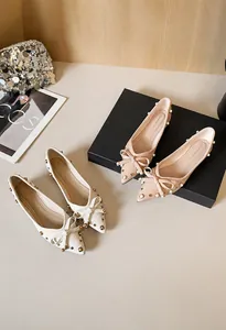 Nahaufnahme der spitzen Ballerinas mit Schleife, Nieten und Perlen aus Leder mit Narbung