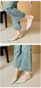Détail de ballerines pointues avec perles blanches, rivets dorés et cuir grainé