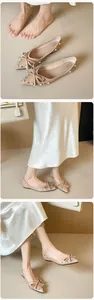 Details von beigen spitzen Ballerinas mit Perlen, Nieten und einer schicken Lederschleife