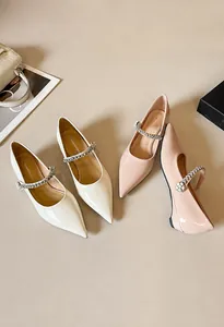 Detailed view of pointed-toe Mary Jane flats with pearl and rhinestone cross straps