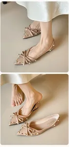Detailansicht der beigen spitzen flachen Schuhe mit Schleife, Perlen und Nieten