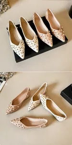 Détail de ballerines pointues en cuir texturé avec perles et clous métalliques sur le dessus