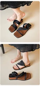 Detail view of square toe platform sandals with black knotted fabric straps and brown sole