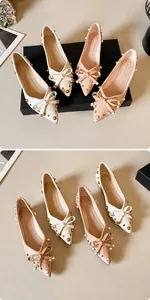 Detailsicht der Schleifendekoration mit Goldnieten und Perlen auf spitzen flachen Schuhen