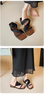 Detail of black cross-strap sandals with square toe and brown suede footbed