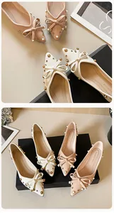Detail von spitzen flachen Schuhen mit Schleife, Perlen und Goldnieten auf Lychee-Leder