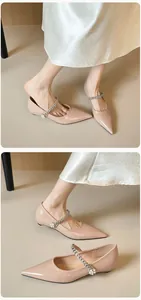 Close-up of pointed-toe Mary Jane flat with rhinestone and pearl strap detailing