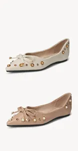 Detail von Schleife und Nieten an spitzen flachen Schuhen aus strukturiertem Leder