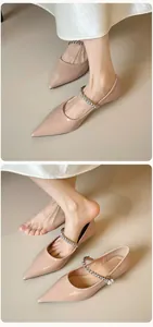Macro view of pointed-toe Mary Janes with sparkling rhinestone and pearl strap detail
