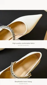 Detail showing pointed toe and sparkling rhinestone strap on glossy off-white Mary Jane shoes