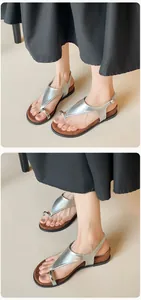 Close-up of silver flat sandals with metal ring detail and adjustable heel strap