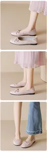 Dettaglio ballerine rosa con fiocco e finitura testurizzata indossate con jeans