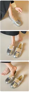 Detailansicht silberner Ballerinas mit Champagner-Stoffrose und gekreuzten Riemen