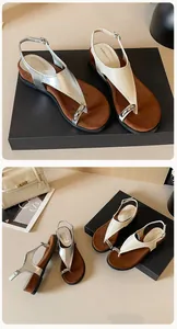 Detail of silver toe-ring sandals featuring polished metal rings and adjustable straps