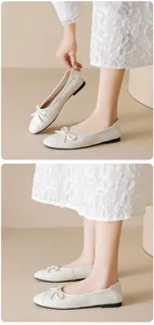Dettaglio delle ballerine intrecciate beige con fiocco e suola piatta nera chic