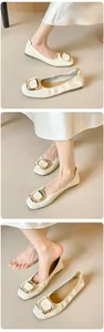 Detail der cremefarbenen flachen Schuhe mit strukturierter Textur und goldener Schnalle
