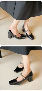 Detail of square-toe black Mary Janes with crystal-embellished strap and block heels