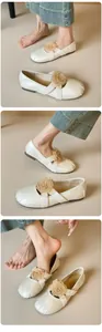 Details von weißen Ballerinas mit großer Stoffrose und elastischen Kreuzriemen