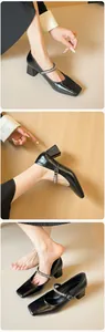 Detail of black patent leather Mary Jane shoes featuring rhinestone straps and square heels